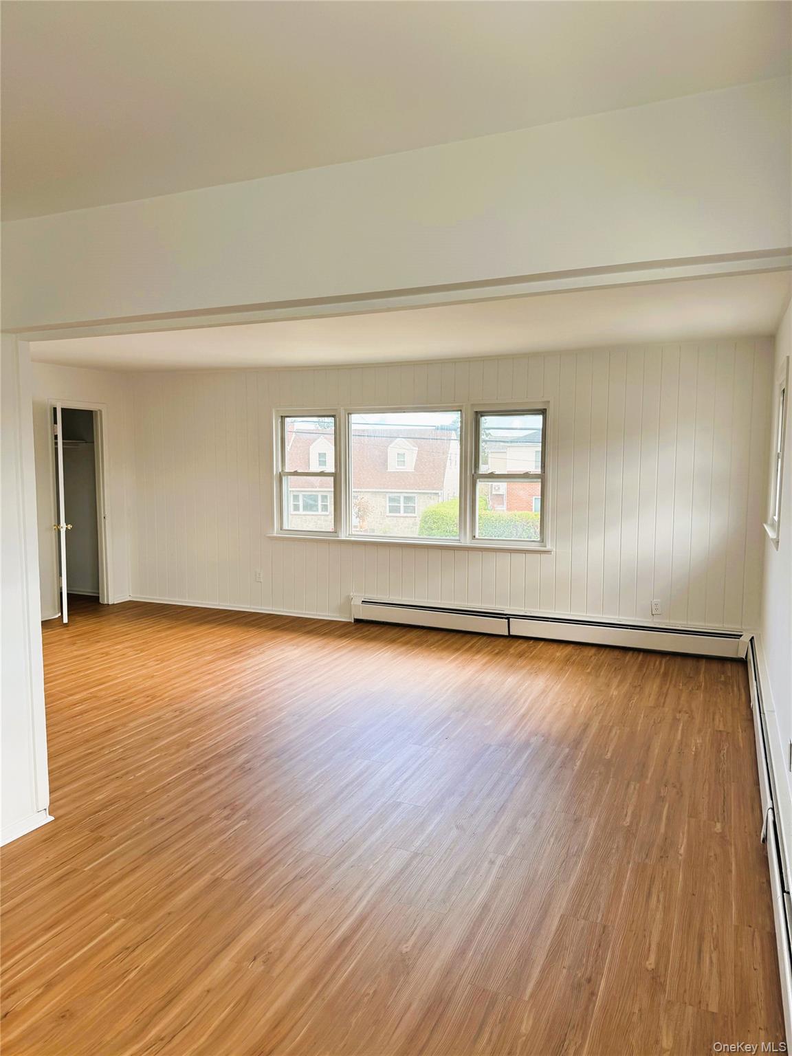 131 Roslyn Road, Unit 1 Mineola, NY 11501 - Photo 13 of 17 a view of an empty room and wooden floor and window