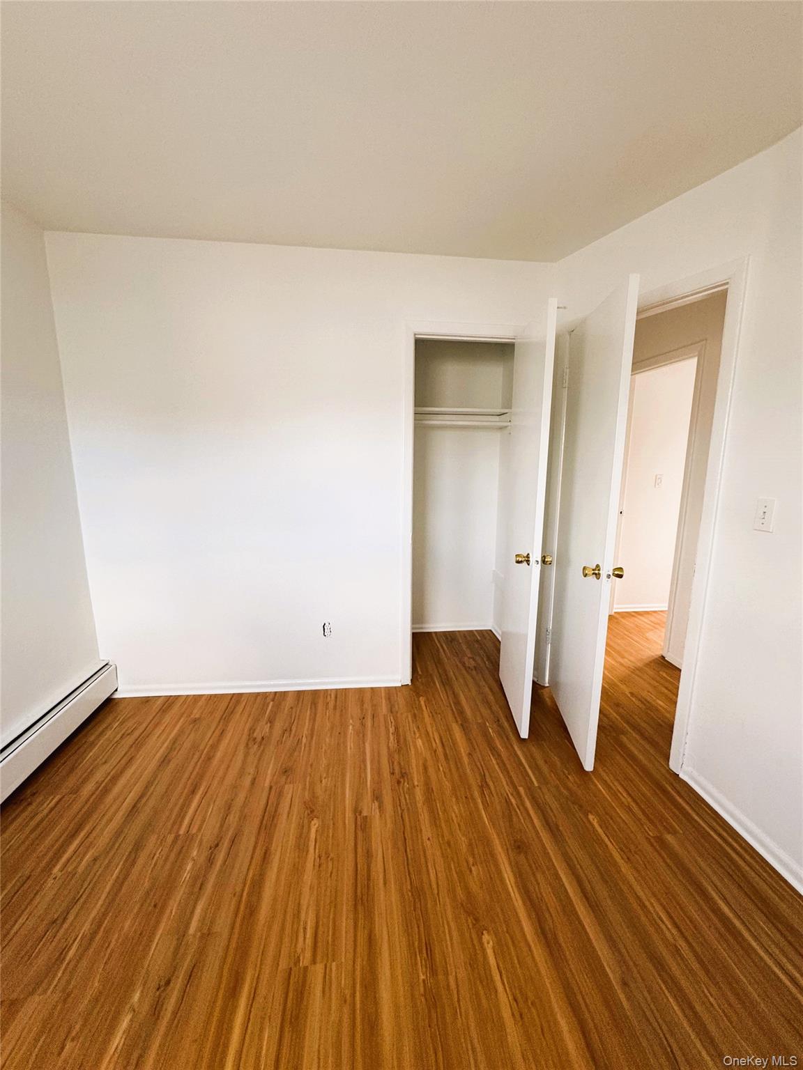 131 Roslyn Road, Unit 1 Mineola, NY 11501 - Photo 14 of 17 an empty room with wooden floor and a window