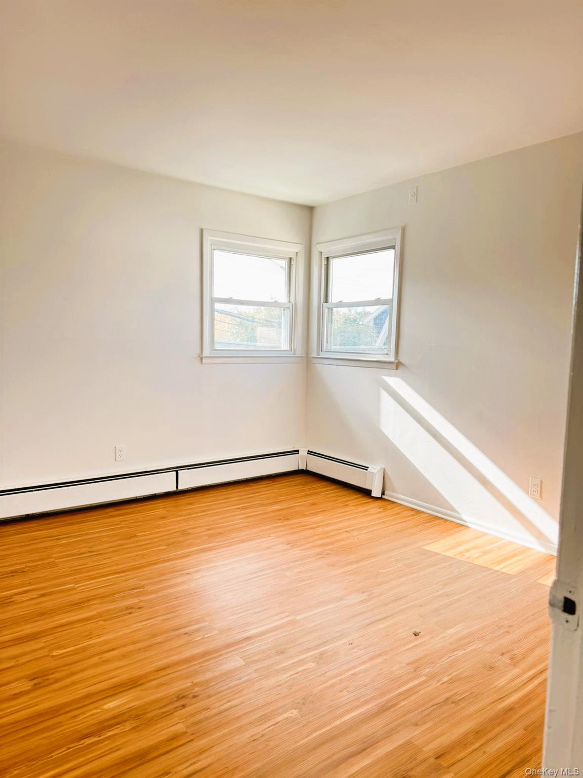 131 Roslyn Road, Unit 1 Mineola, NY 11501 - Photo 15 of 17 a view of an empty room with wooden floor and a window