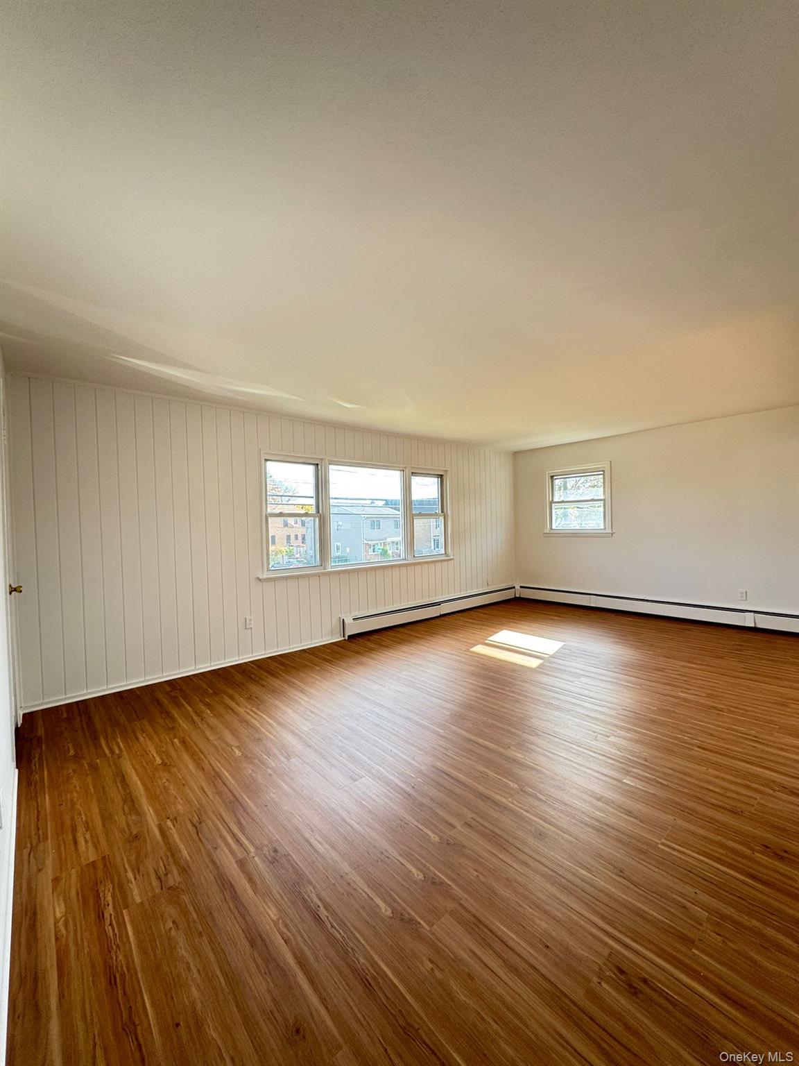 131 Roslyn Road, Unit 1 Mineola, NY 11501 - Photo 2 of 17 wooden floor in an empty room with a window