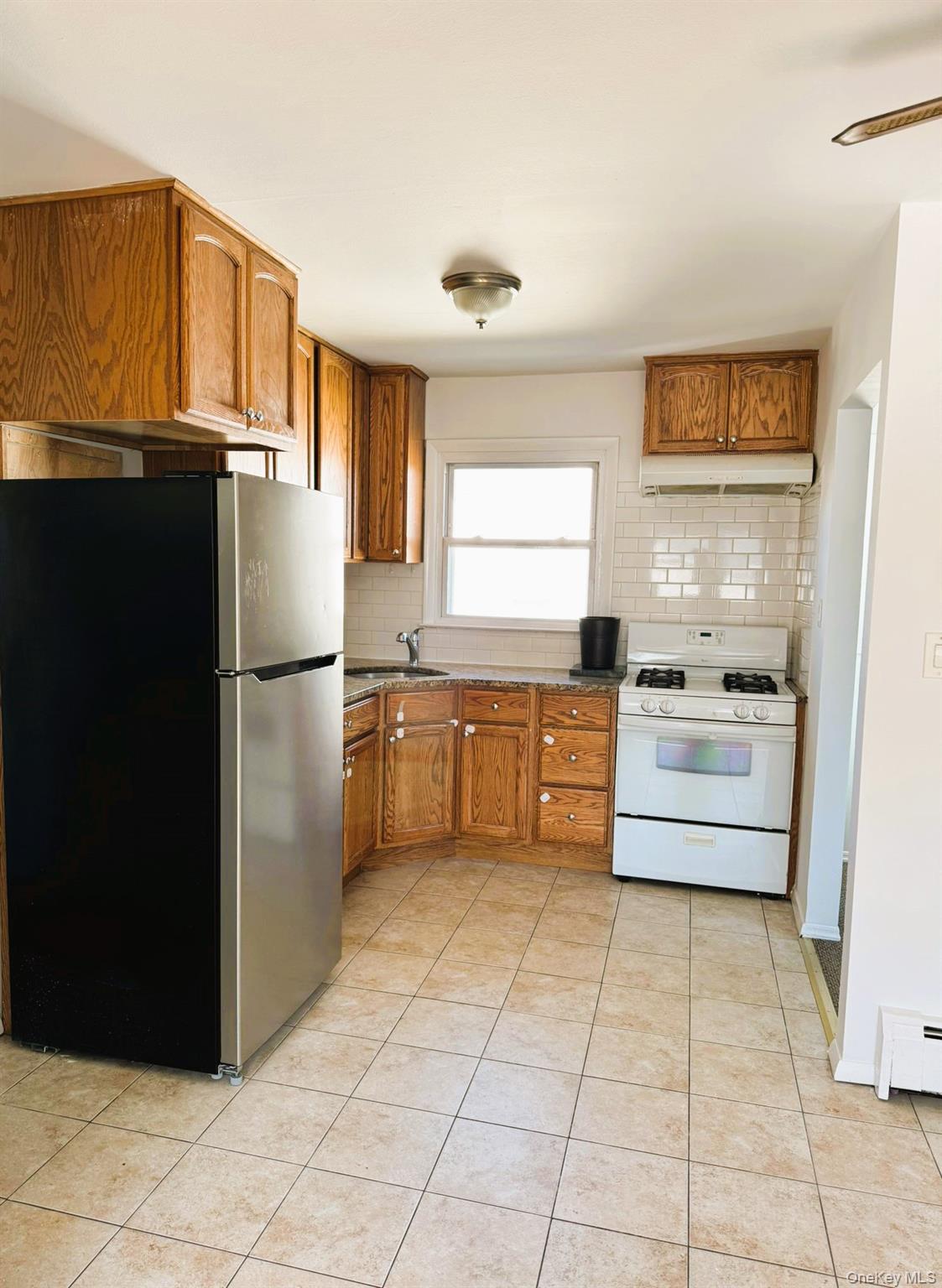 131 Roslyn Road, Unit 1 Mineola, NY 11501 - Photo 4 of 17 a kitchen with granite countertop a refrigerator and a sink