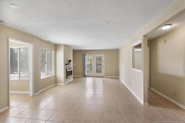 a view of an empty room with a fireplace and a window
