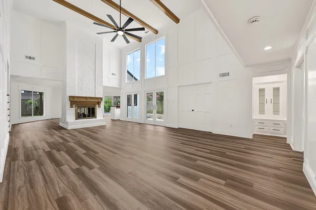 a view of a livingroom with wooden floor and a ceiling fan a fireplace
