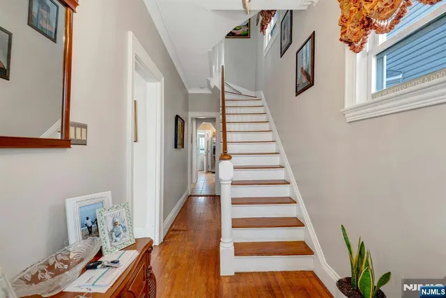 a view of a hallway with wooden floor and stairs