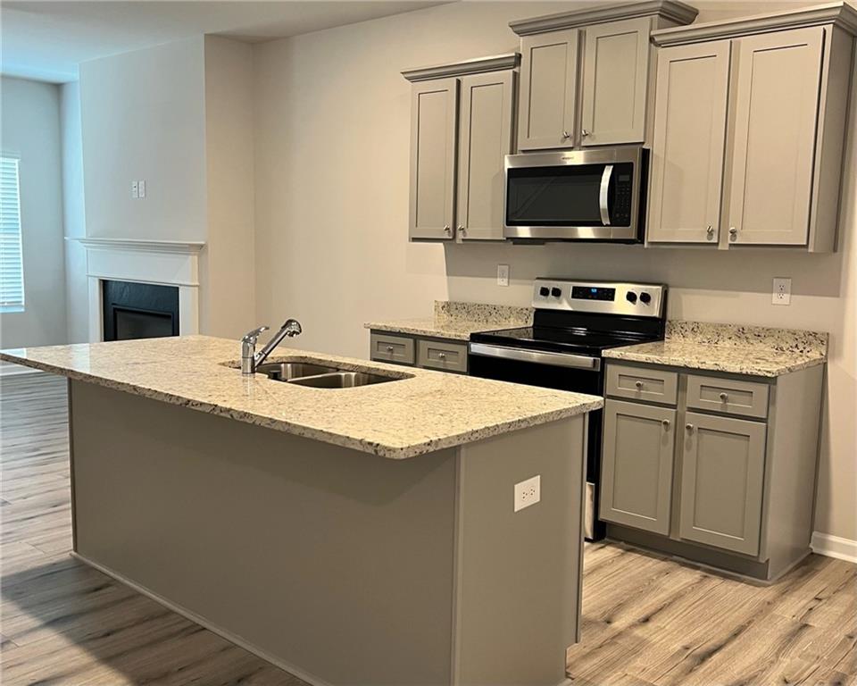 4352 Shaffer Ct Union, Unit 58 Union City, GA 30291 - Photo 7 of 19 a kitchen with granite countertop a sink a stove top oven and cabinetry