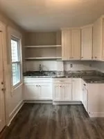 a kitchen with granite countertop white cabinets and white appliances