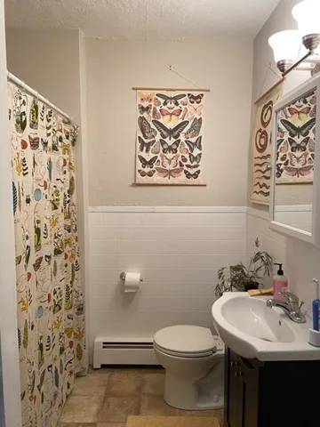 a bathroom with a sink and mirror with toilet