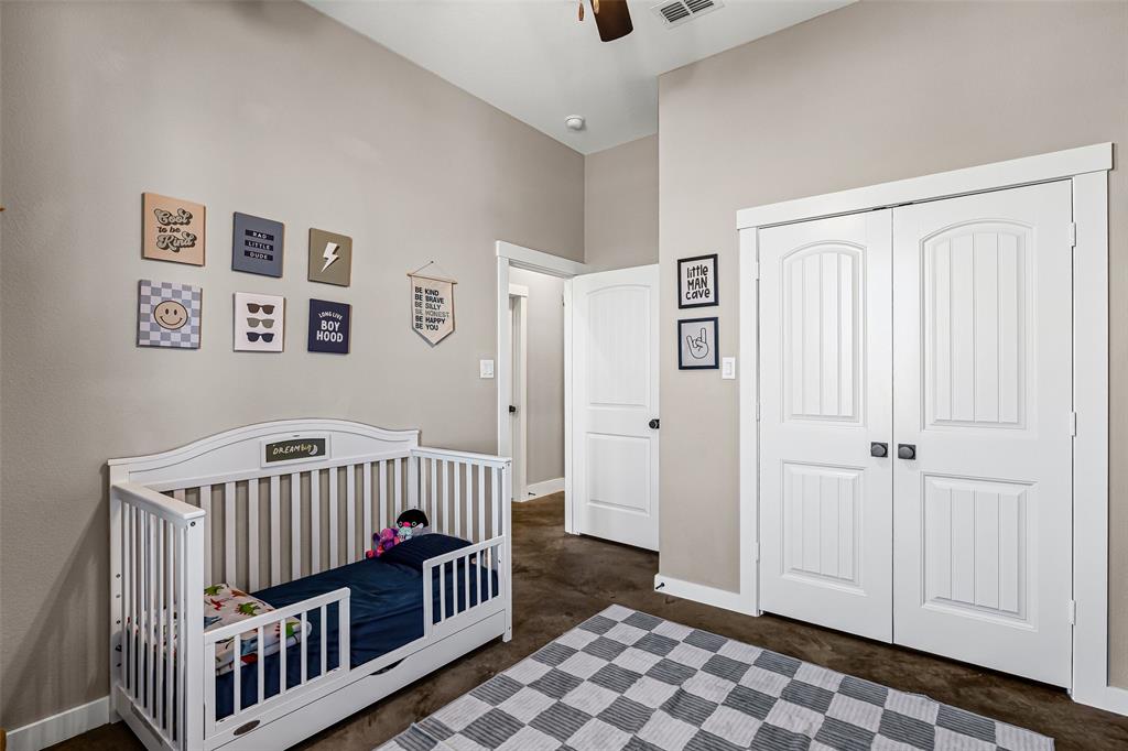 310 Runyan Rnch Road Tolar, TX 76476 - Photo 20 of 35 Bedroom with ceiling fan, a crib, a closet, and concrete flooring