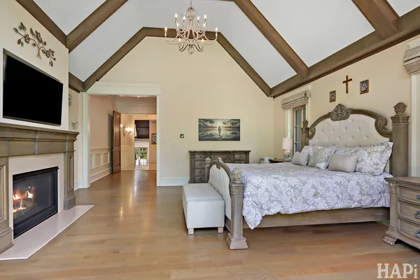 a spacious bedroom with a bed and a flat screen tv