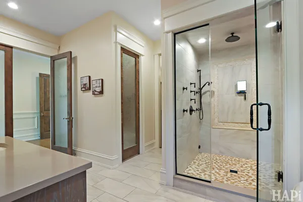 a bathroom with a toilet a sink a mirror a vanity and shower