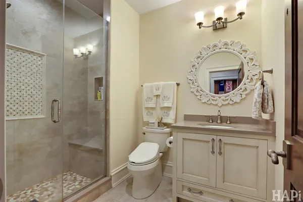 a kitchen with stainless steel appliances a dining table chairs refrigerator and microwave