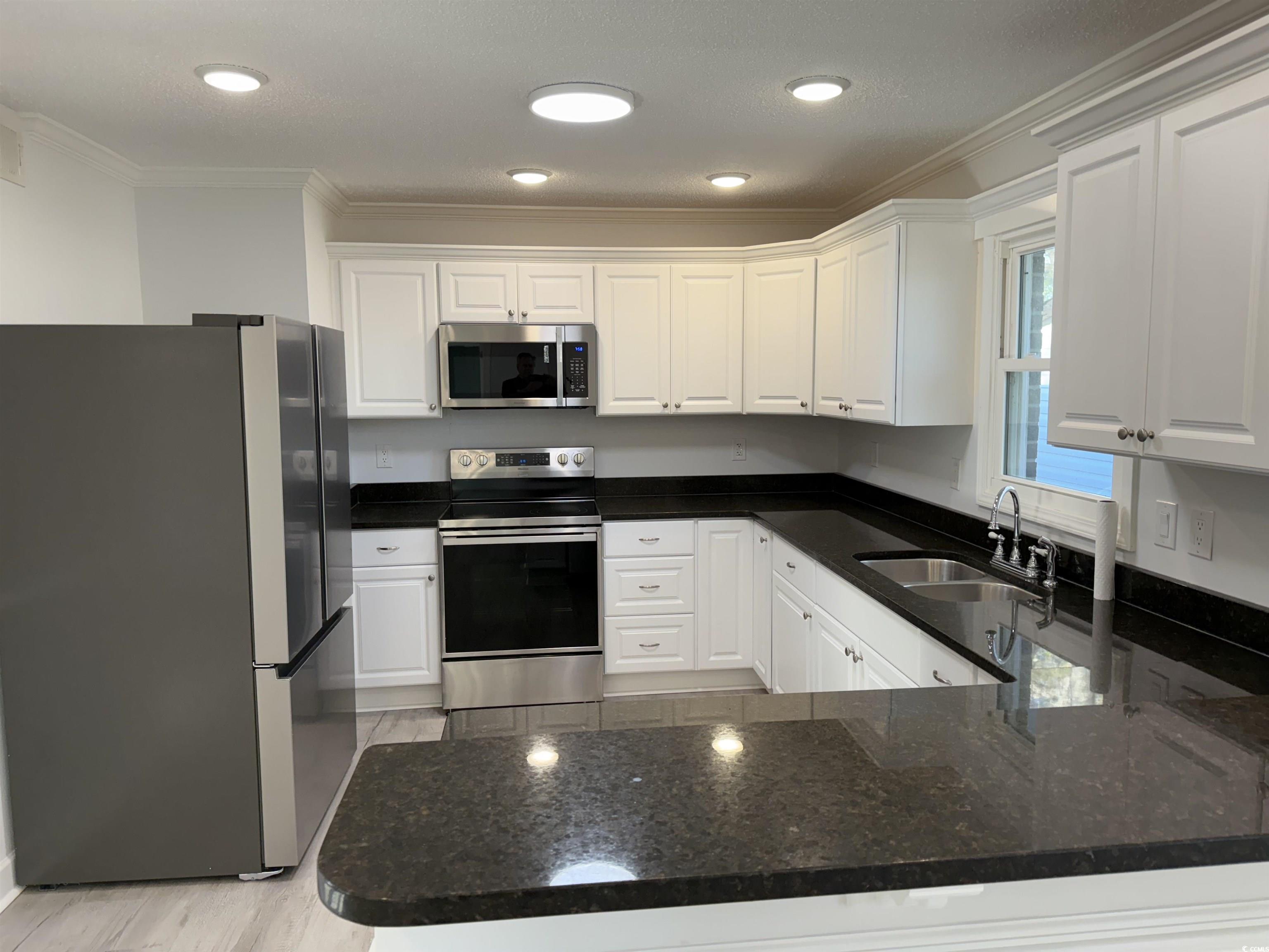 926 Forest Loop Road Conway, SC 29527 - Photo 3 of 14 Kitchen with a sink, appliances with stainless steel finishes, ornamental molding, and white cabinetry