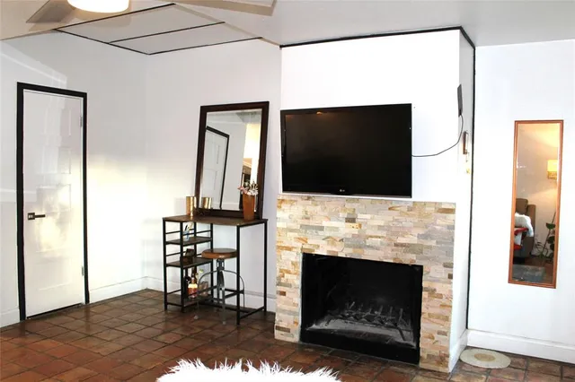 a living room with a fireplace a flat screen tv and a fireplace