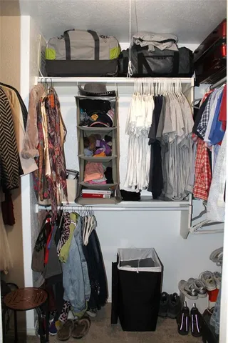 a view of walk in closet with clothes and shoes