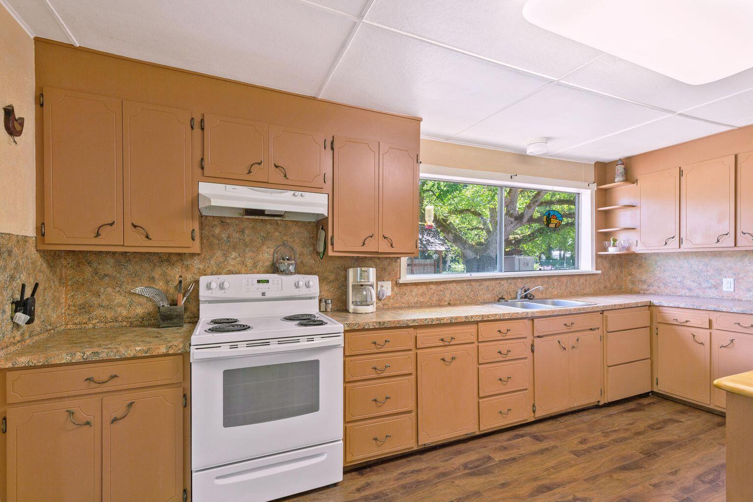 4601 Lower River Road Grants Pass, OR 97526 - Photo 14 of 36 a kitchen with a stove a sink and wooden cabinets