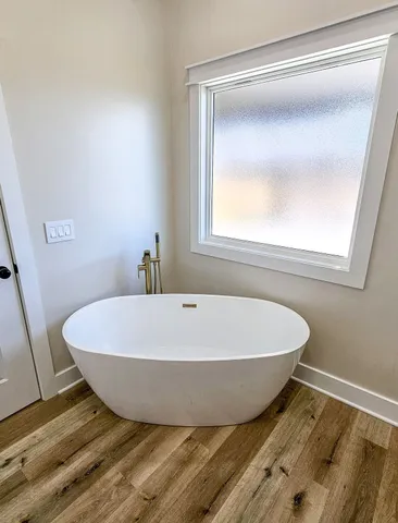 a white tub sitting next to a window