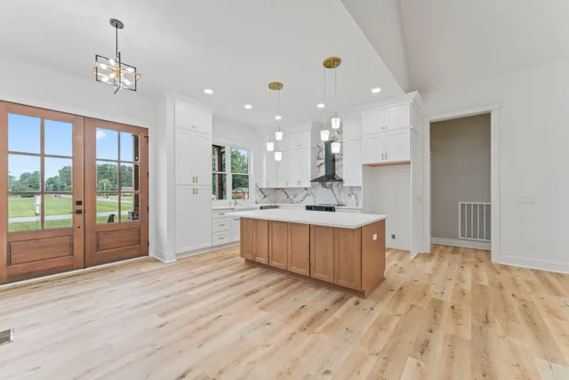 a large kitchen with stainless steel appliances kitchen island a large counter top and a wooden floors