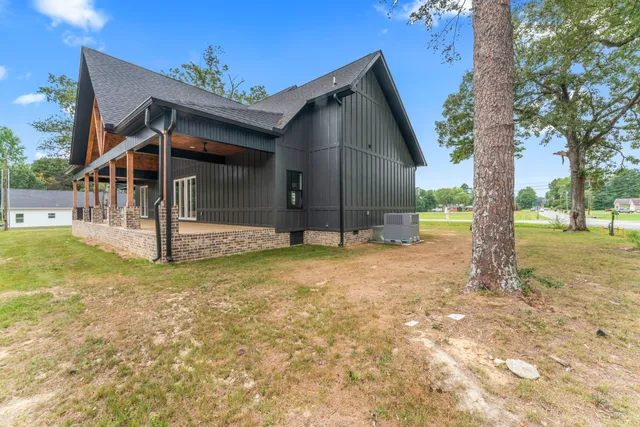 a view of a house with backyard and trees