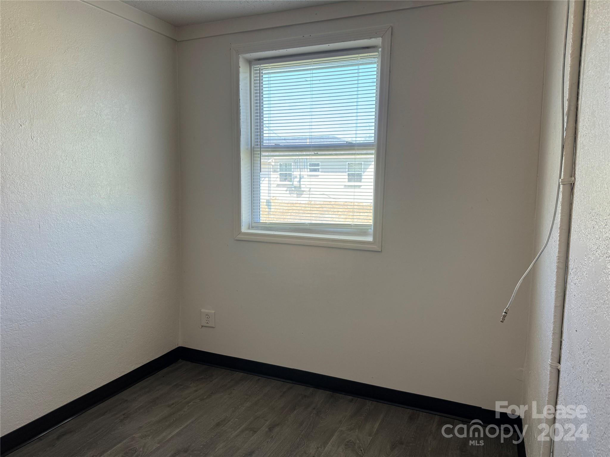 200 York Street, Unit M6 Chester, SC 29706 - Photo 12 of 14 a view of an empty room with wooden floor and a window