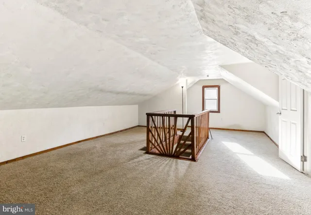 a view of staircase with railing and white walls