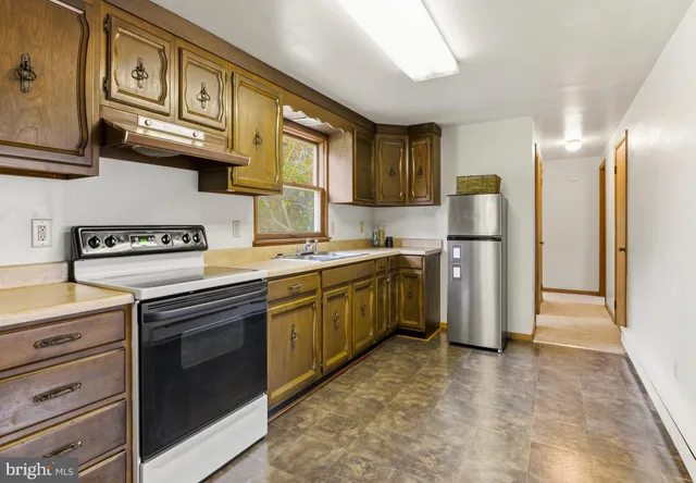 a kitchen with stainless steel appliances granite countertop a refrigerator and a sink