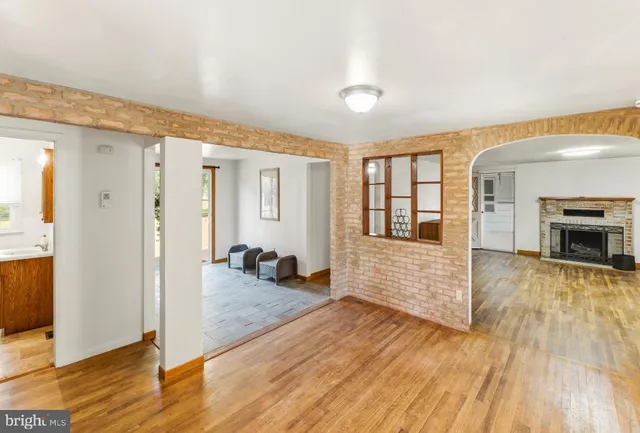 a view of a hallway with wooden floor and a living room