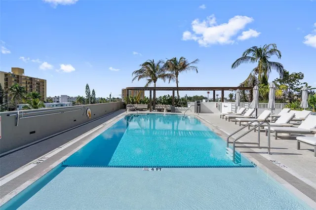a view of a swimming pool with outdoor seating and a potted plants