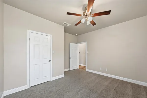 an empty room with a ceiling fan and a window
