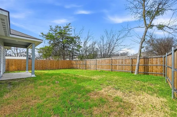 a view of a yard with a fence and trees