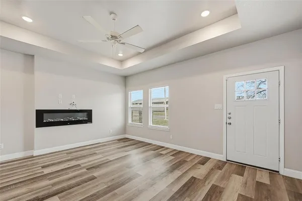 an empty room with windows and ceiling fan