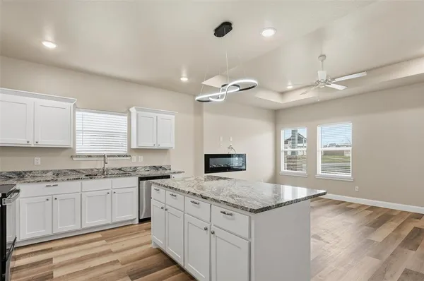 a kitchen with granite countertop a sink stove and cabinets