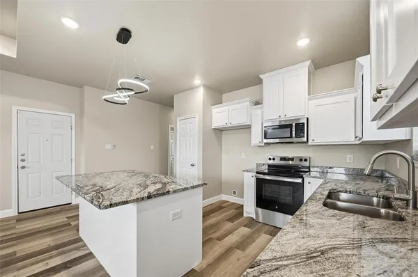 a kitchen with stainless steel appliances granite countertop a sink stove and refrigerator