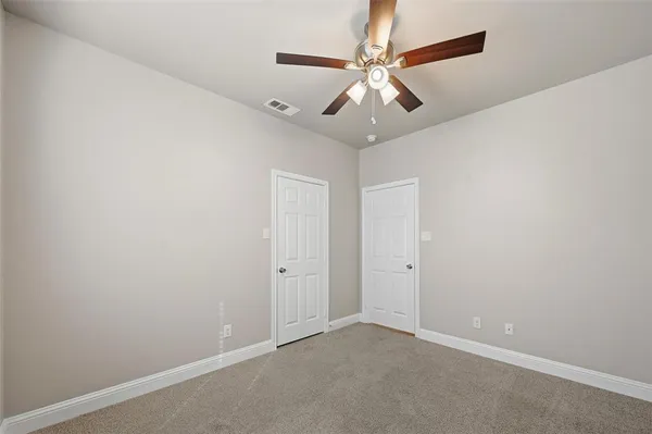 an empty room with a fan and a fan