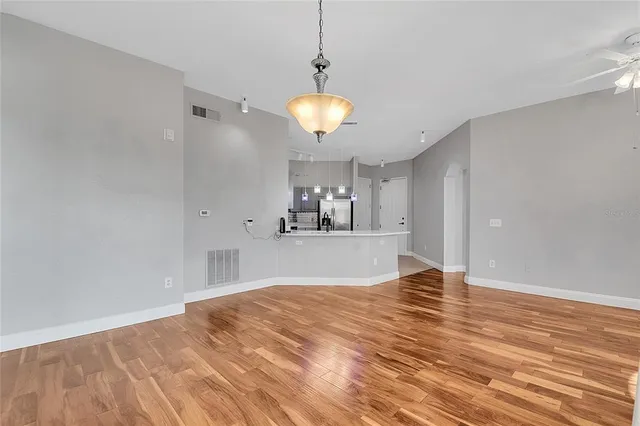 a view of a room with wooden floor and a ceiling fan