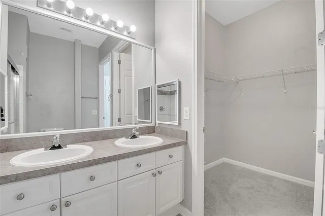 a bathroom with double sink and a mirror