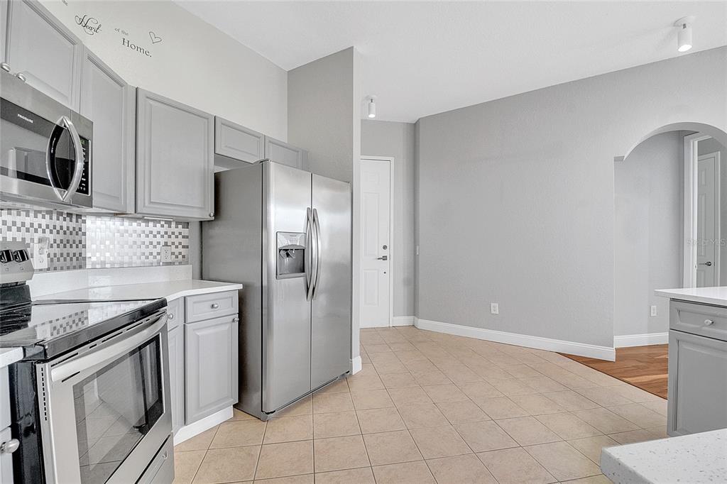 617 Terrace Ridge Circle, Unit 617 Davenport, FL 33896 - Photo 28 of 40 a kitchen with stainless steel appliances granite countertop a refrigerator and a stove top oven