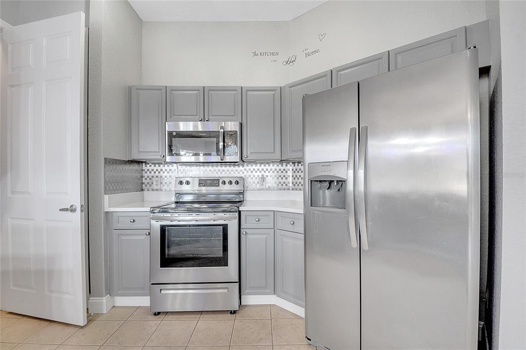 617 Terrace Ridge Circle, Unit 617 Davenport, FL 33896 - Photo 4 of 40 a kitchen with cabinets and stainless steel appliances