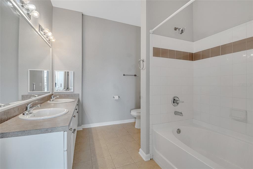 617 Terrace Ridge Circle, Unit 617 Davenport, FL 33896 - Photo 8 of 40 a bathroom with a tub sink and mirror