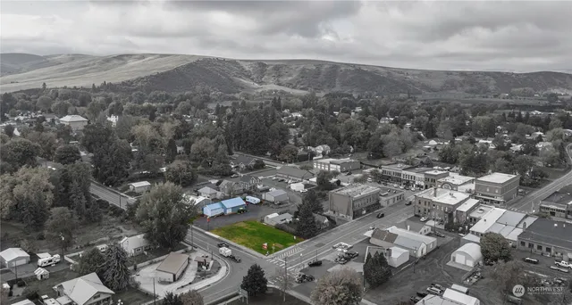 an aerial view of a house with a yard and mountain view in back