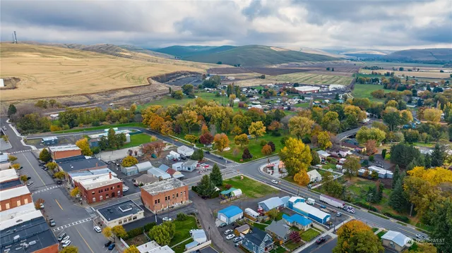 an aerial view of a city with lots of residential buildings ocean and mountain view in back