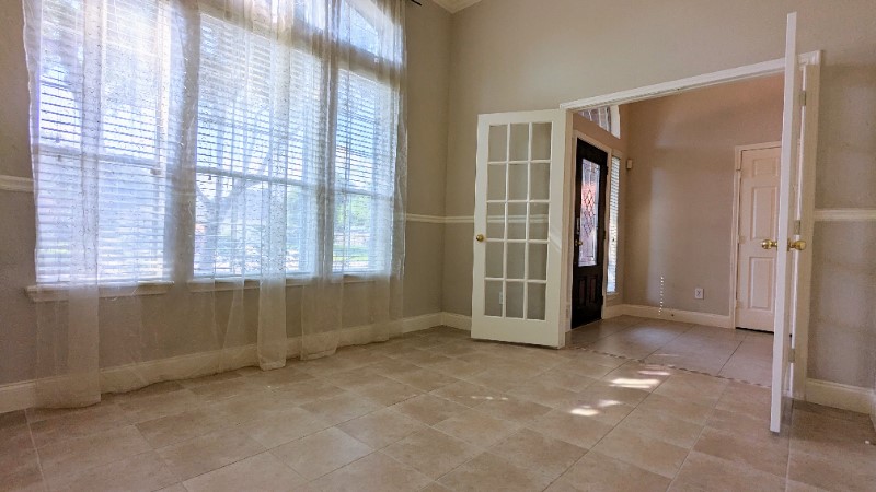20909 Springport Court Katy, TX 77450 - Photo 6 of 39 Bright and inviting room with large windows, elegant French doors, and tiled flooring, perfect for a cozy sitting area or home office.