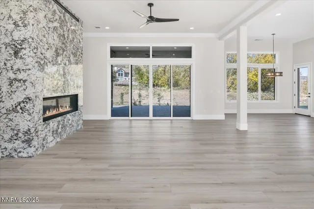 an empty room with wooden floor fireplace and windows