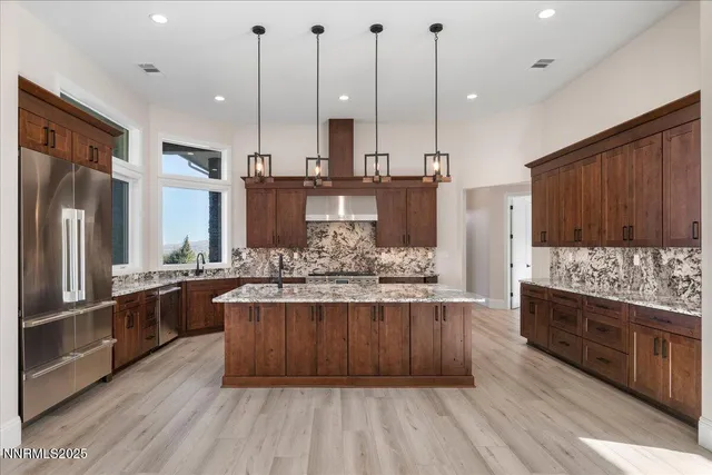 a kitchen with kitchen island granite countertop a sink and a wooden floor