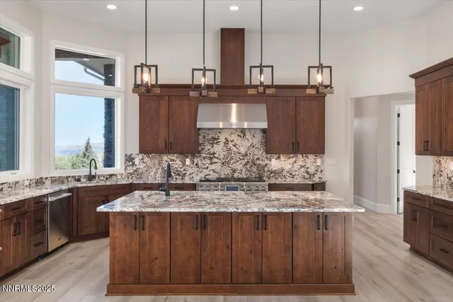 a kitchen with stainless steel appliances granite countertop wooden cabinets sink and stove