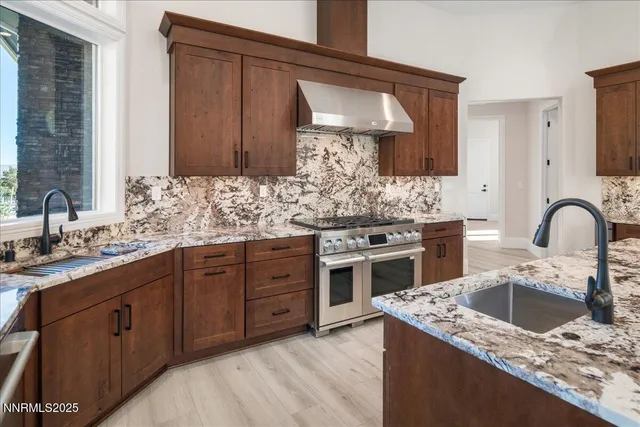 a large kitchen with stainless steel appliances granite countertop a stove and a sink