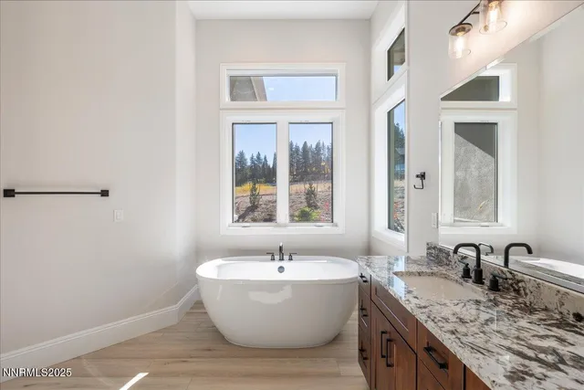 a spacious bathroom with a tub sink and mirror