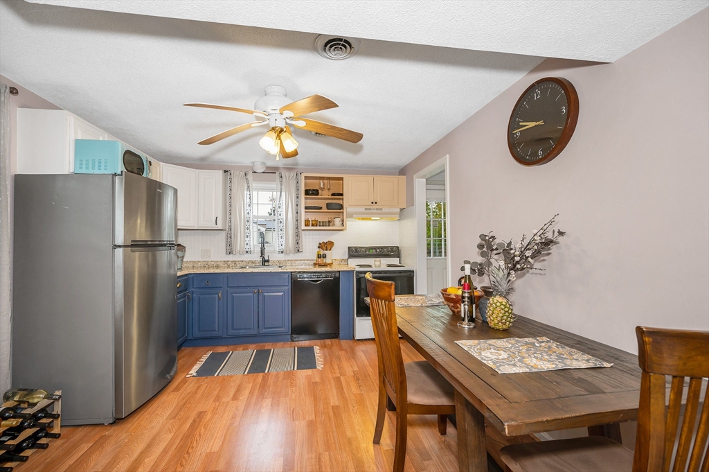 43 Constitution Way, Unit 43 Methuen, MA 01844 - Photo 7 of 25 a kitchen with stainless steel appliances granite countertop a refrigerator a stove a sink dishwasher and a dining table with wooden floor