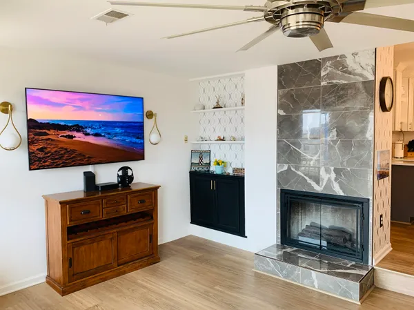 a living room with furniture a fireplace and a chandelier