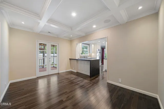 wooden floor in an empty room with a kitchen