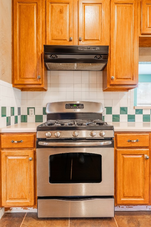 1706 Apache Trail Round Rock, TX 78665 - Photo 12 of 40 Kitchen featuring gas range, backsplash, and brown cabinetry